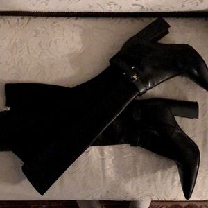 Elegant knee high heeled black tall boot.